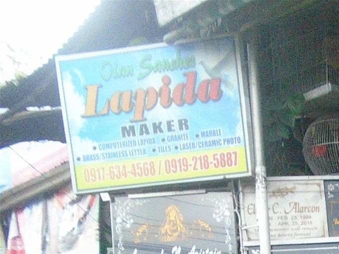 On the ride back to Fred's, took a drive-by shot of one of the handful of lapida (grave tablet) maker shops across from the Cabanatuan City Public Cemetery.
