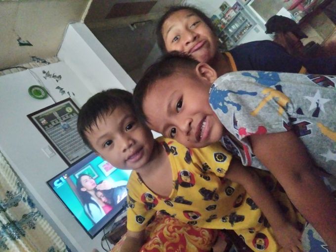 Aaron and Lara with a little cousin at Larry and Lori's place in San Jose City. TV in the Philippines has two main offerings: screwball comedy and Sturm und Drang. The latter seems to be on behind the kiddos. Photo by ?